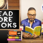 Man wearing glasses reading a book titled 'How to Talk to Anyone,' sitting next to a stack of books with a chalkboard displaying the words 'READ MORE BOOKS.' The image also features a badge that says 'Amazon Editors' Best Books of 2024 So Far.